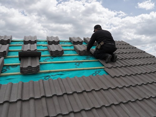 main-laying-dark-grey-tiles-on-residential-roof